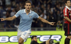 The best player of Lazio Miroslav Klose is flying over the field