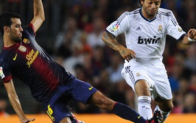 Игрок Барселоны Серхио Бускетс борется за мяч