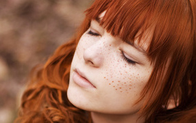 Girl with freckles covering her eyes