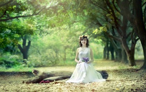 Девушка сидит на бревне