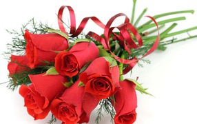 Украшенные красные розы на белом столе на восьмое марта