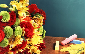 Букет и мелки на столе в День знаний 1 сентября
