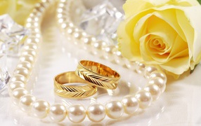 Свадебные кольца и жёлтая роза