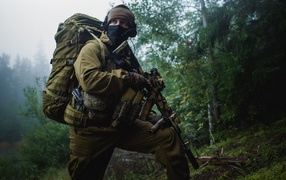 Солдат в снаряжении с автоматом АК