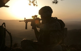 Солдат с оружием на закате