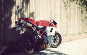 Мощный мотоцикл у забора