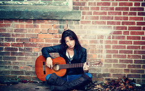 Девушка с гитарой у стены