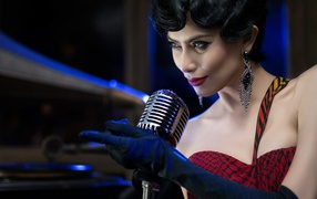 женщина с микрофоном в бардовом