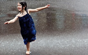 Happy child runs in the rain