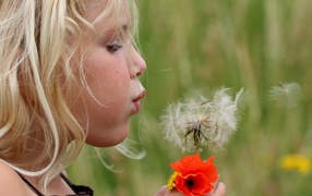 	   Girl blowing on a dandelion flower