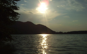 Солнце над водой озера Клопайнер Зее, Австрия