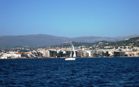 Яхта на фоне города на курорте Порт Де Фрежюс, Франция