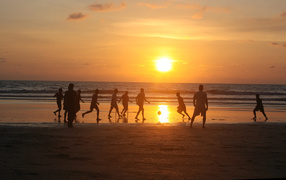 Парни играют в футбол на пляже в Гоа