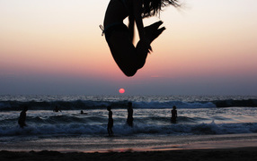 Girl jumping on the beach in Varkala