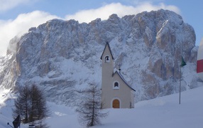 Церковь на фоне Альп на горнолыжном курорте Валь Гардена, Италия