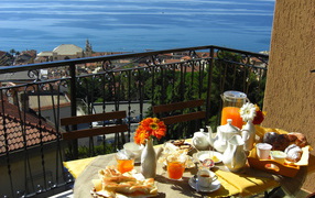 Отдых в кафе на террассе на курорте в Пьетра Лигуре, Италия