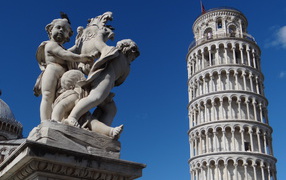 Статуя на фоне башни в Пизе, Италия