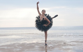 Балерина в черном на пляже