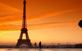 Человек фотографирует Эйфелеву башню