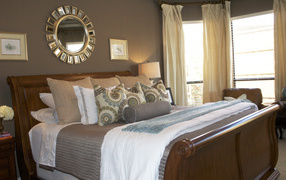 Круглое зеркало над кроватью в спальне