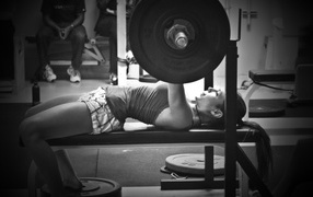 Спортивная девушка поднимаeт тяжести