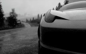 Black and white photo of a car in the rain