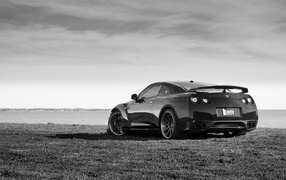 Black and white photo of a car on the beach