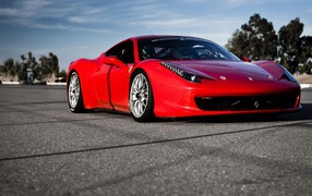 Красный спортивный автомобиль на гладком сером асфальте