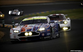 Гоночный Aston Martin с горящими фарами