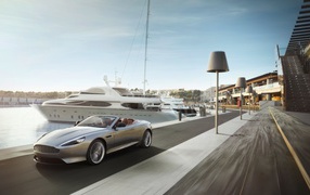 Convertible Aston Martin on the background of yachts
