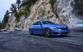 Голубой BMW M4 на фоне скалы