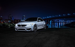 Серебристый BMW на фоне ночных огней
