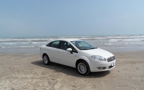 White Fiat on beach sand