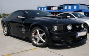 Красивый черный Мустанг на парковке