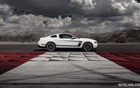 Белый Ford Mustang на фоне гор и облаков