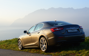 Коричневый Maserati на фоне гор
