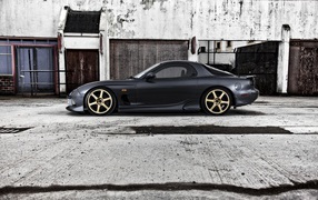 Черная Mazda RX-7 на сером бетоне