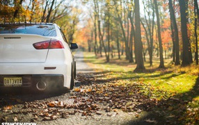 Белый автомобиль Mitsubishi Lancer Evo X в парке