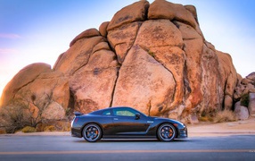 Черный Nissan GT-R у подножия скалы