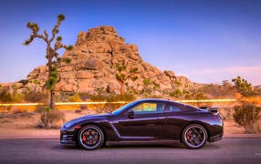 Автомобиль Nissan GT-R на фоне скалы