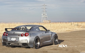 Silver racing Nissan GT-R on the background of the field