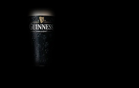 Темное пиво Guinness на темном фоне