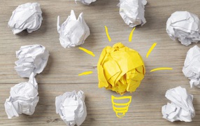 Комок желтой бумаги среди белых