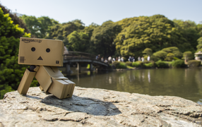 Картонный человечек на камне в саду