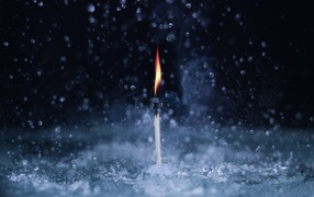 Пламя спички среди капель воды