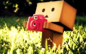 Картонный человечек с фотоаппаратом в траве