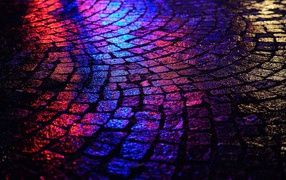 Блики ночных огней на брусчатке улицы