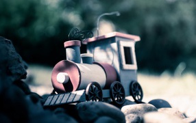 Игрушечный паровоз на камнях