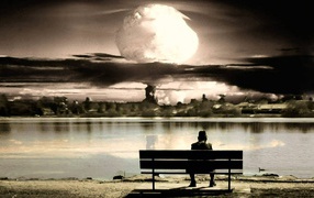 Человек смотрит на ядерный взрыв сидя на скамье