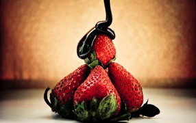 Шоколад льется на клубнику